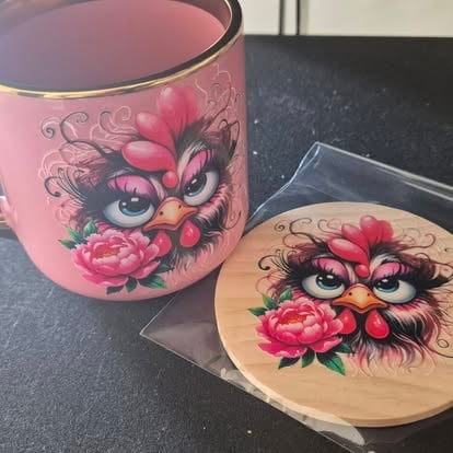 Pink ceramic mug and matching coaster with decorative cat face and red floral design